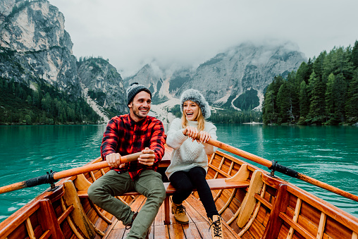 Romantic couple on a boat visiting an alpine lake at Braies Italy. 